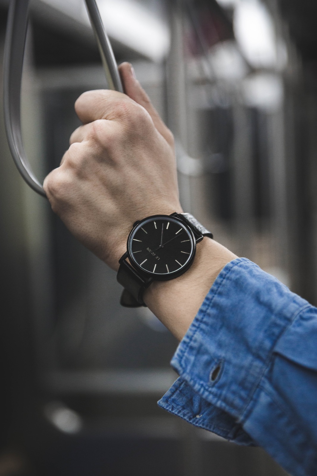 Black wristwatch and leather strap photographed on a wrist